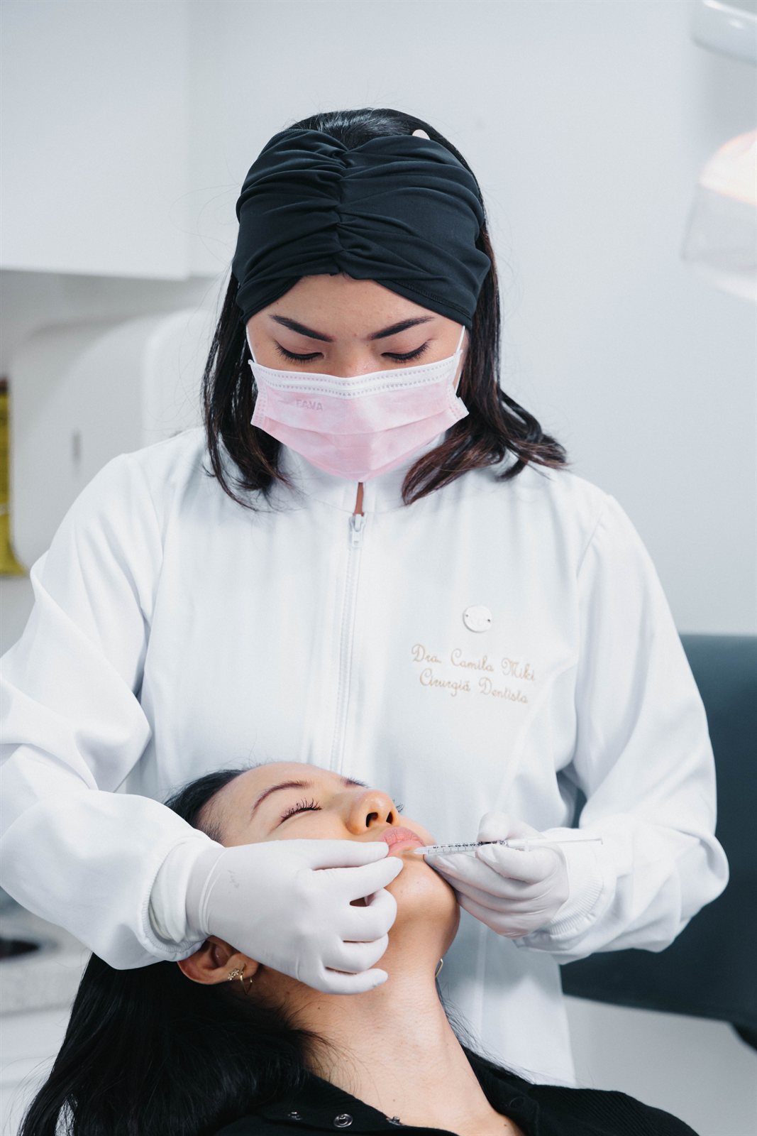 Dra. Camila Miki realizando um procedimento de harmonização orofacial